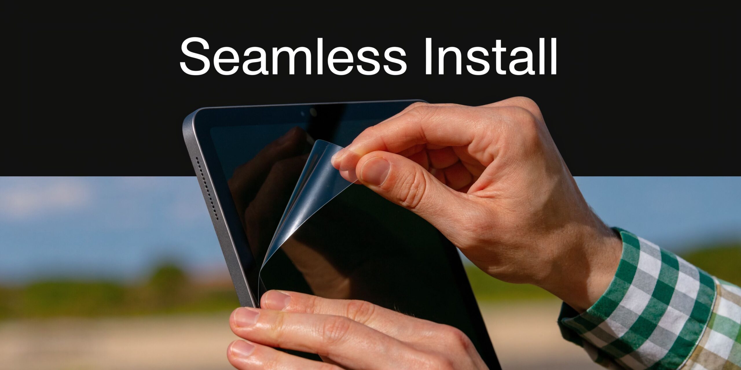 A close-up view of hands applying a screen protector to an iPad in a professional manner.
